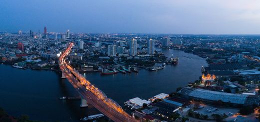 Abendlich beleuchtete Ufersilhouette Bangkoks, Thailand