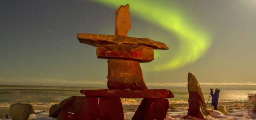 Inukshuk mit Aurora borealis an der Hudson Bay