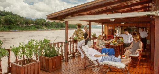 Einladendes Sonnendeck mit Blumen und frischen Früchten, Bar-Service, gemütlichen Liegen, Sesseln und Sofas